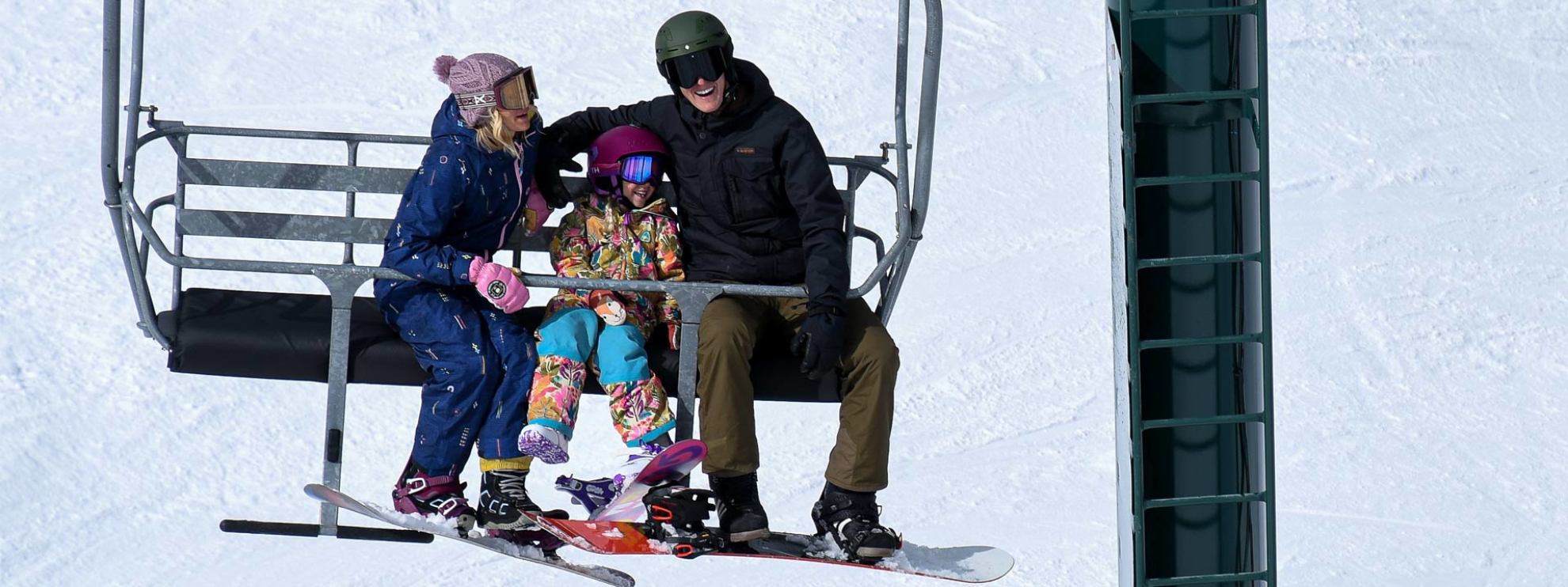 A family with their young child on a ski lift at Brighton Resort