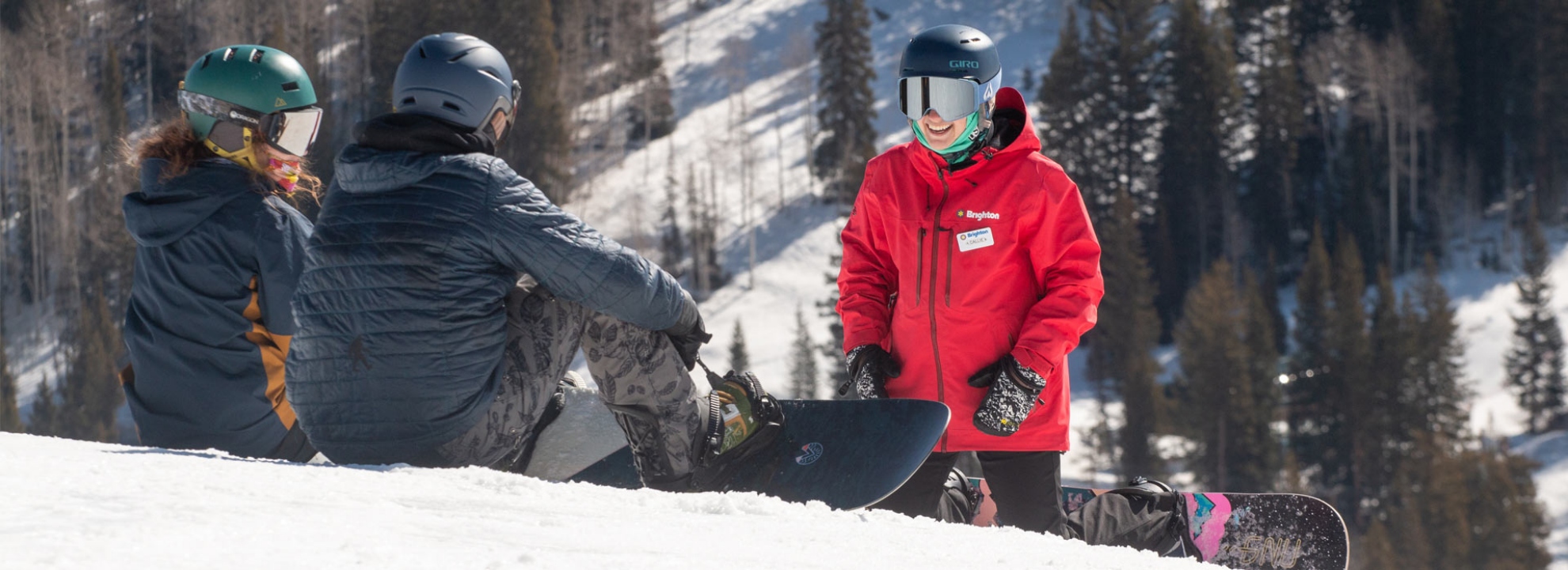 A Brighton Resort instructor teaching two snowboarders how to ride. 