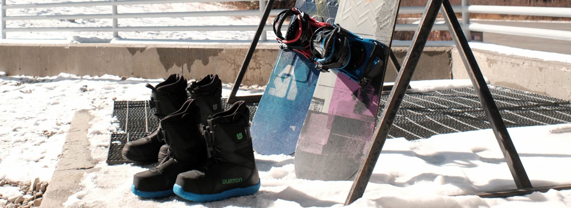 Snowboard and boots leaning against a ski rack