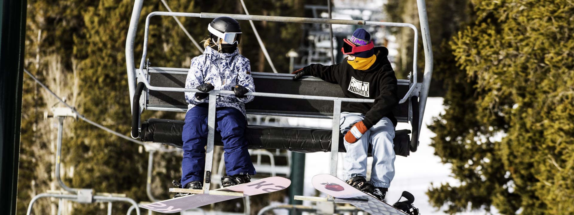 Snowboarders riding a lift at Brighton Resort