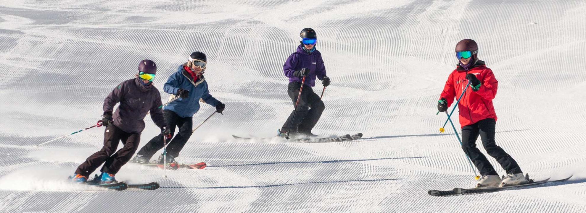 Women learning to ski together with a Brighton Snowsports School instructor